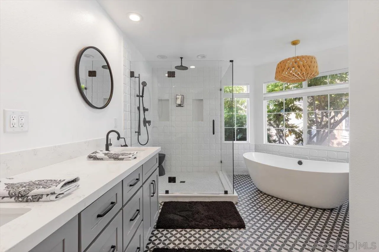 219 Jacob Lane Encinitas, CA 92024 - Photo 22 of 46 a spacious bathroom with a sink a mirror a bathtub and a window