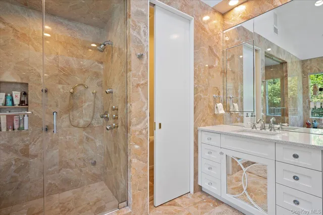 a bathroom with a shower sink and mirror