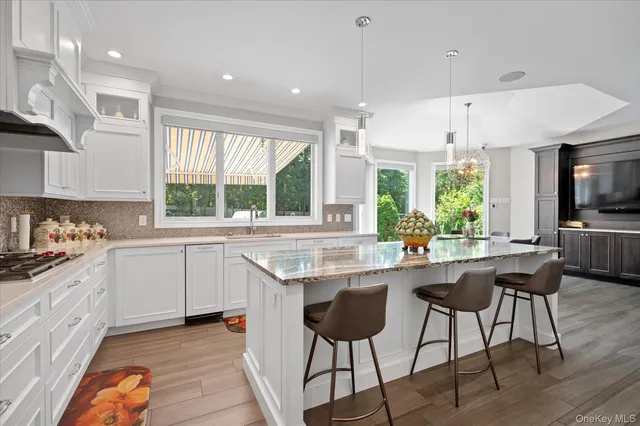 a kitchen with stainless steel appliances kitchen island granite countertop a sink and a stove