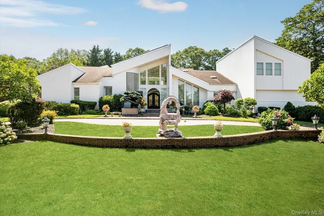 a view of house with a big yard and potted plants
