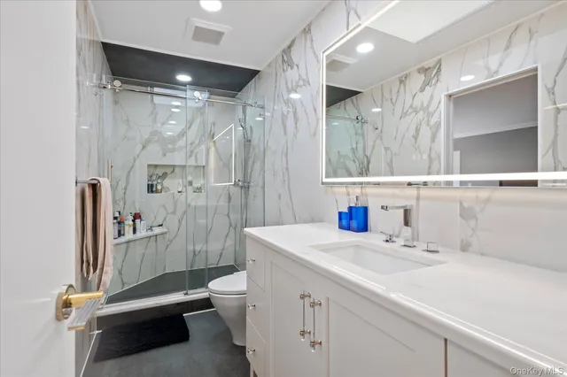 a bathroom with a sink a toilet and shower