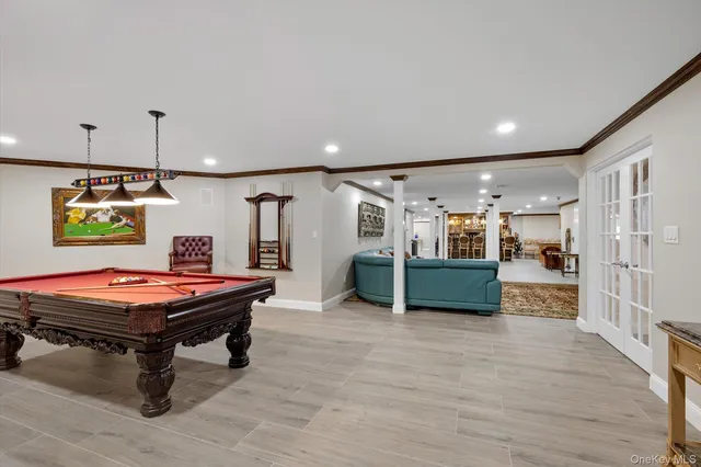 a room with furniture pool table and wooden floor