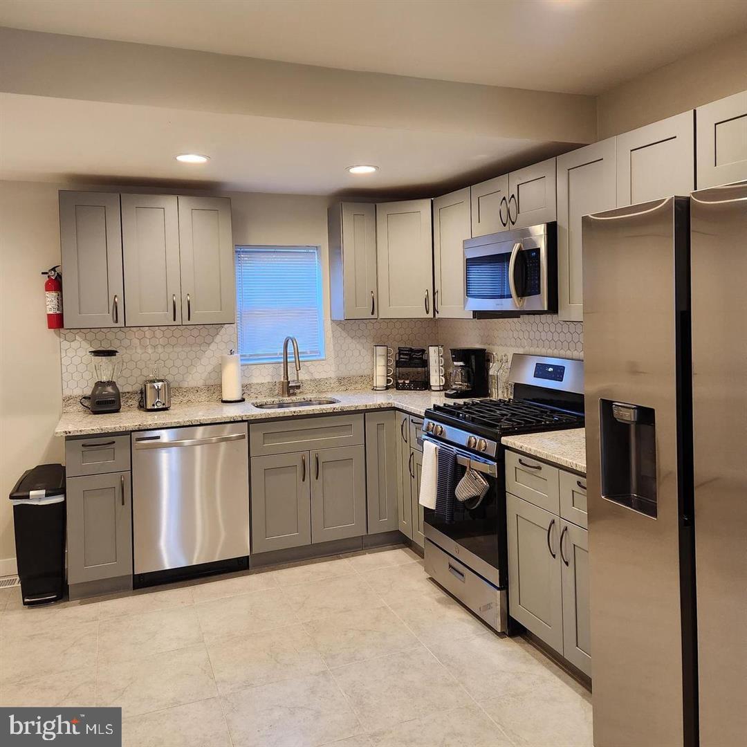 1247 South Newkirk Street Philadelphia, PA 19146 - Photo 5 of 20 a kitchen with stainless steel appliances granite countertop a refrigerator sink and stove