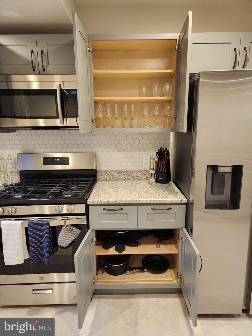 1247 South Newkirk Street Philadelphia, PA 19146 - Photo 6 of 20 a kitchen with stainless steel appliances granite countertop a stove and a microwave