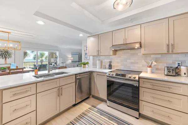 a kitchen with a sink stainless steel appliances and white cabinets