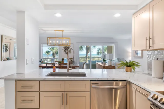 a kitchen with stainless steel appliances granite countertop a refrigerator a stove and a sink