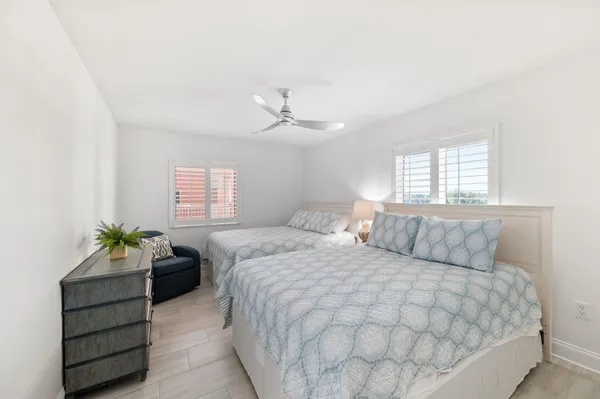 a spacious bedroom with a bed a dresser and a window