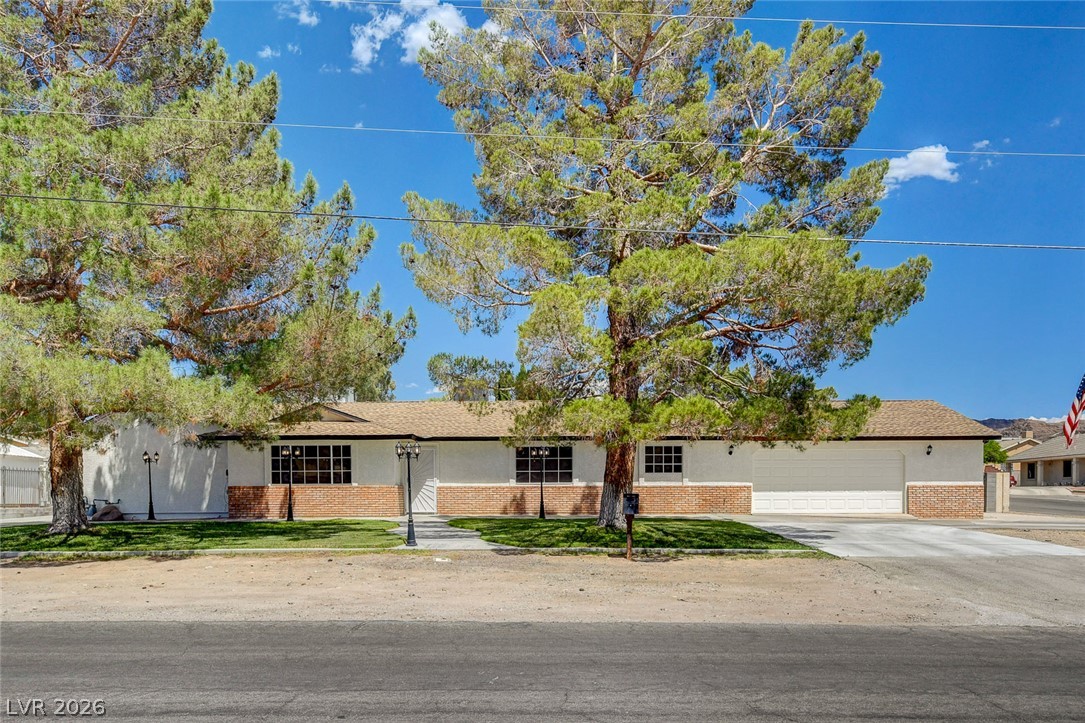 1810 Pinto Road Henderson, NV 89002 - Photo 3 of 53 Mature trees shade this single-story home with a wide driveway and integrated garage.