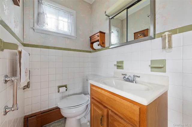 a bathroom with a sink a toilet and mirror