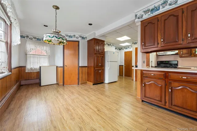 a view of a kitchen with a sink dishwasher a refrigerator and cabinets