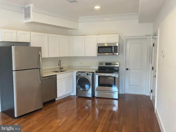 a kitchen with a refrigerator sink and stove top oven
