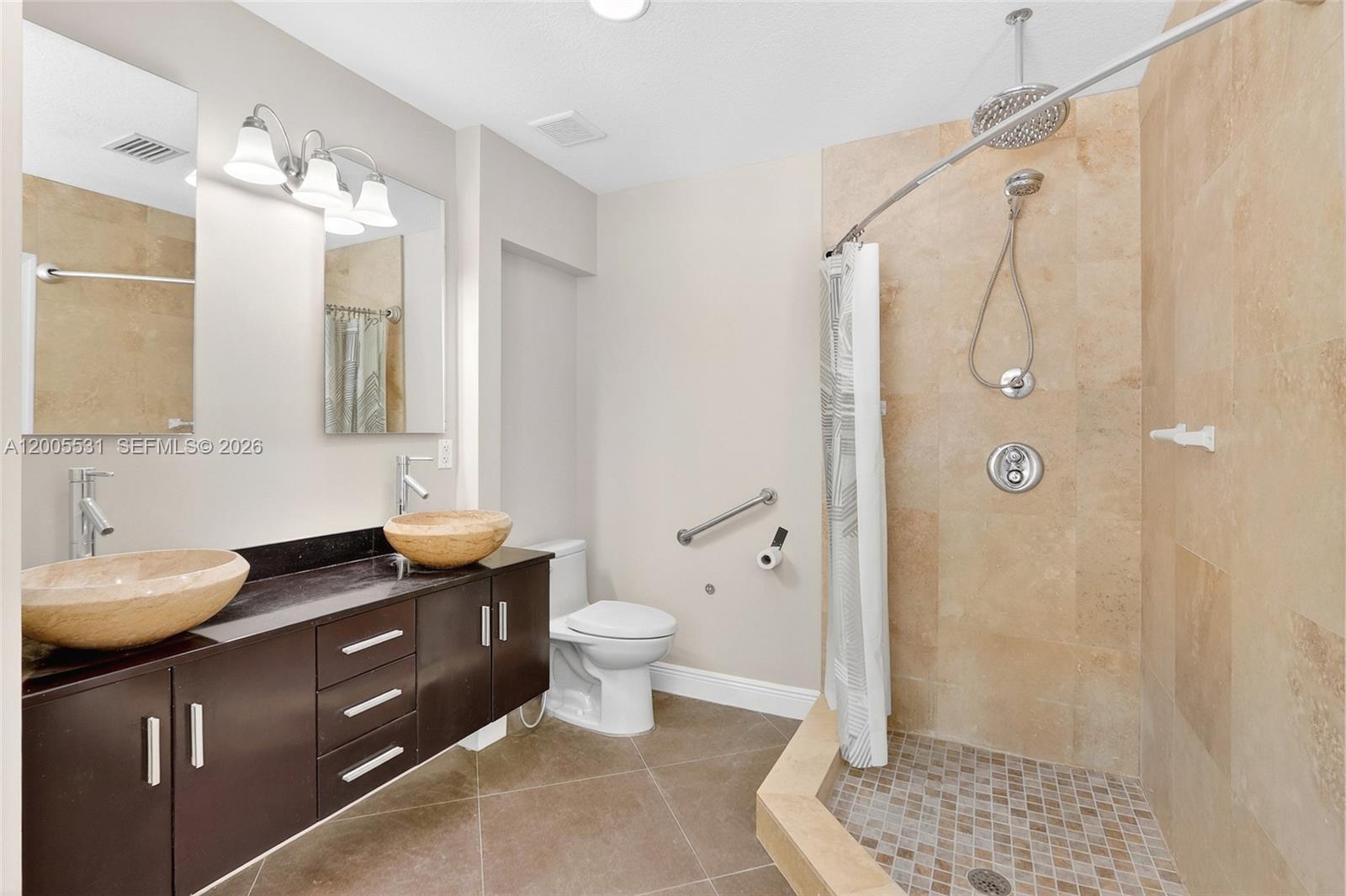 5310 Southwest 72nd Street Miami, FL 33143 - Photo 14 of 20 a bathroom with a double vanity sink toilet and shower