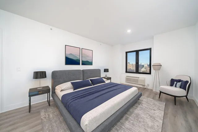 a view of a room with wooden floor and mirror