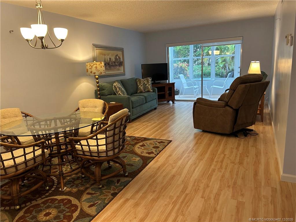 2950 Southeast Ocean Boulevard, Unit 1323 Stuart, FL 34996 - Photo 5 of 19 a living room with furniture and a chandelier