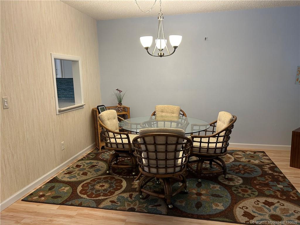 2950 Southeast Ocean Boulevard, Unit 1323 Stuart, FL 34996 - Photo 6 of 19 a view of a dining room with furniture and chandelier