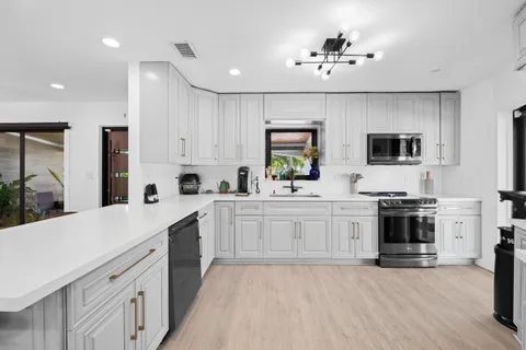 a kitchen with stainless steel appliances a stove sink and cabinets