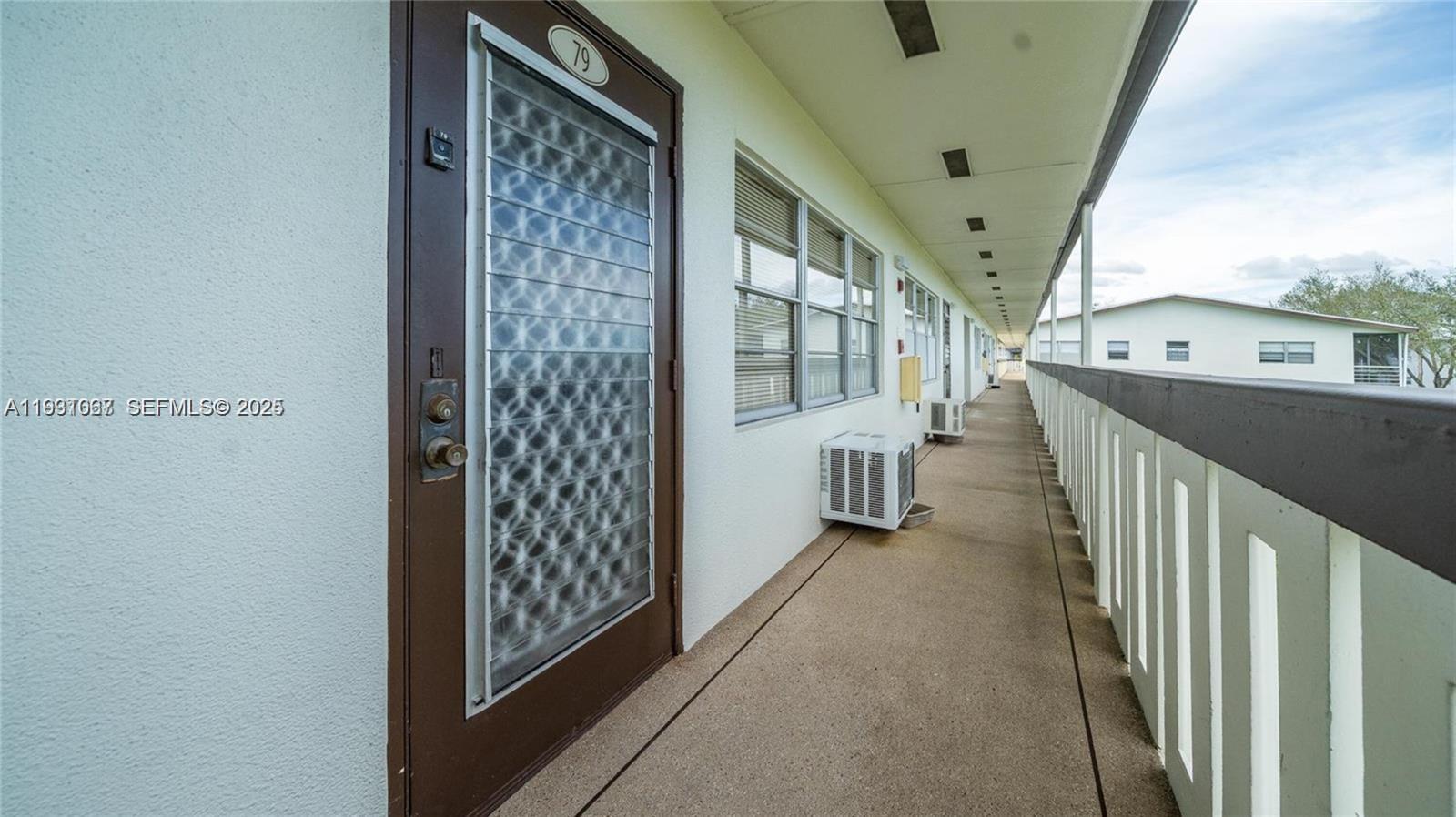 79 Suffolk B, Unit 79 Boca Raton, FL 33434 - Photo 6 of 10 a view of a hallway with wooden floor and staircase