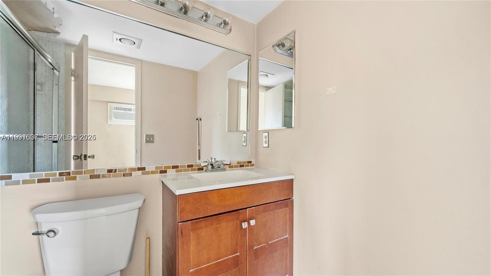 79 Suffolk B, Unit 79 Boca Raton, FL 33434 - Photo 8 of 10 a bathroom with a sink a toilet and a mirror