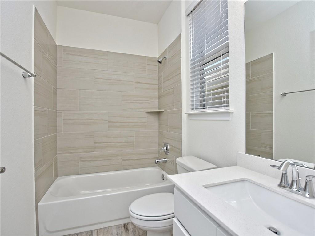 1836 Turtle Bay Loop Leander, TX 78641 - Photo 11 of 32 Guest Bathroom featuring a full vanity with an integrated sink, polished chrome faucet, and a large mirror