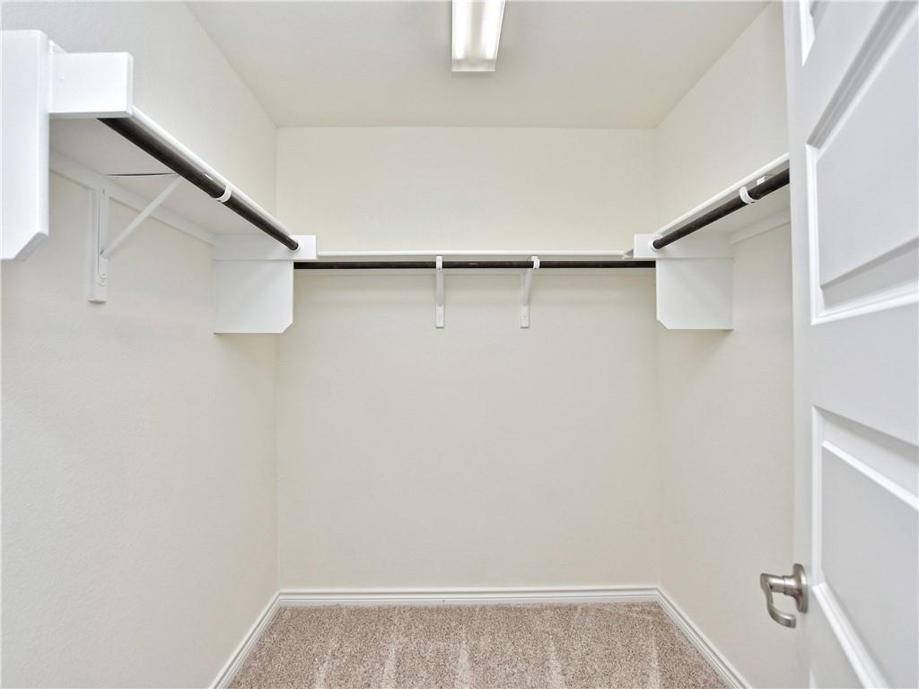1836 Turtle Bay Loop Leander, TX 78641 - Photo 14 of 32 Walk-in closet featuring light-toned carpeting, white walls, and built-in shelving with hanging rods