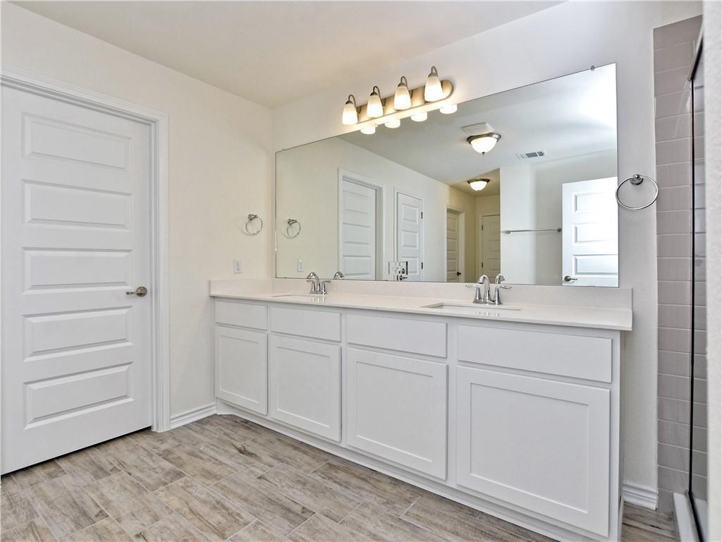 1836 Turtle Bay Loop Leander, TX 78641 - Photo 16 of 32 Bathroom featuring a dual-sink vanity with white cabinetry and a light-toned countertop