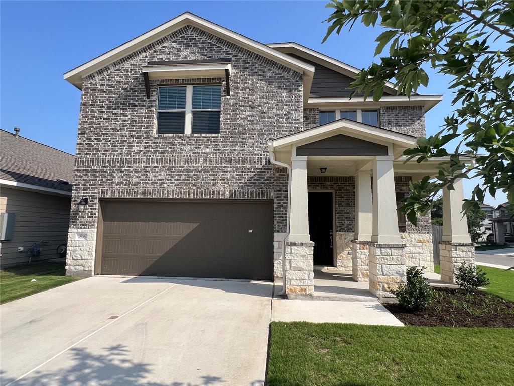 1836 Turtle Bay Loop Leander, TX 78641 - Photo 2 of 32 Two-story residence featuring a brick facade with stone accents, a covered entry porch, a two-car garage, and a concrete driveway