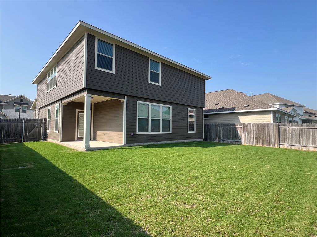 1836 Turtle Bay Loop Leander, TX 78641 - Photo 23 of 32 Expansive green lawn bordering a two-story residence with horizontal siding