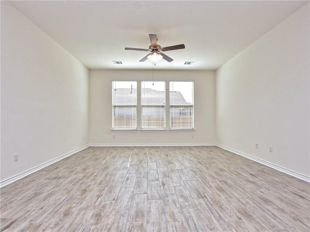 1836 Turtle Bay Loop Leander, TX 78641 - Photo 8 of 32 Spacious room featuring wood-finish flooring and three large windows with horizontal blinds