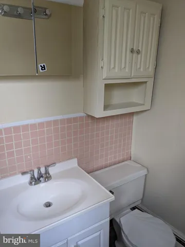 a bathroom with a sink a toilet and mirror