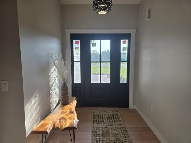a view of a dining room and livingroom with furniture wooden floor a chandelier