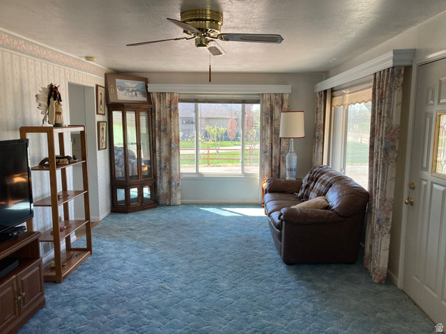 200 South 2800th Street West Ogden, UT 84404 - Photo 9 of 42 Sitting room featuring a ceiling fan, dark carpet, healthy amount of natural light, and a textured ceiling