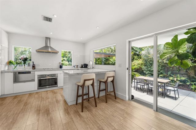 a kitchen with stainless steel appliances a stove top oven and a table