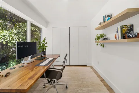 a view of a workspace with furniture and a window