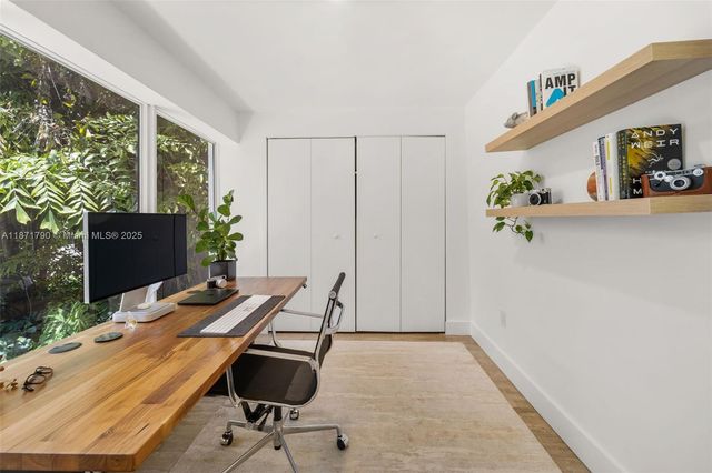 a view of a workspace with furniture and a window