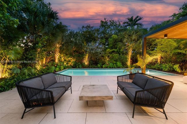 an outdoor sitting area with furniture and a garden