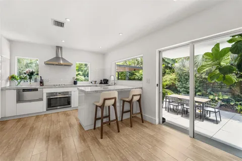 a kitchen with stainless steel appliances a stove top oven and a table