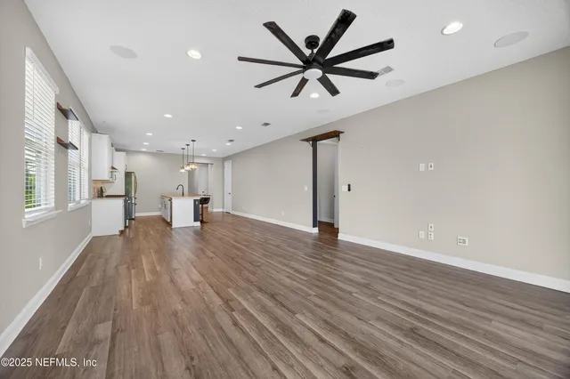 a view of a big room with wooden floor and windows