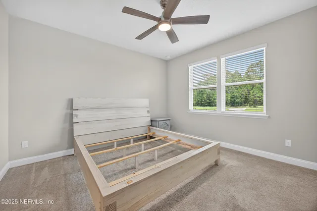 a view of a livingroom with a ceiling fan and window