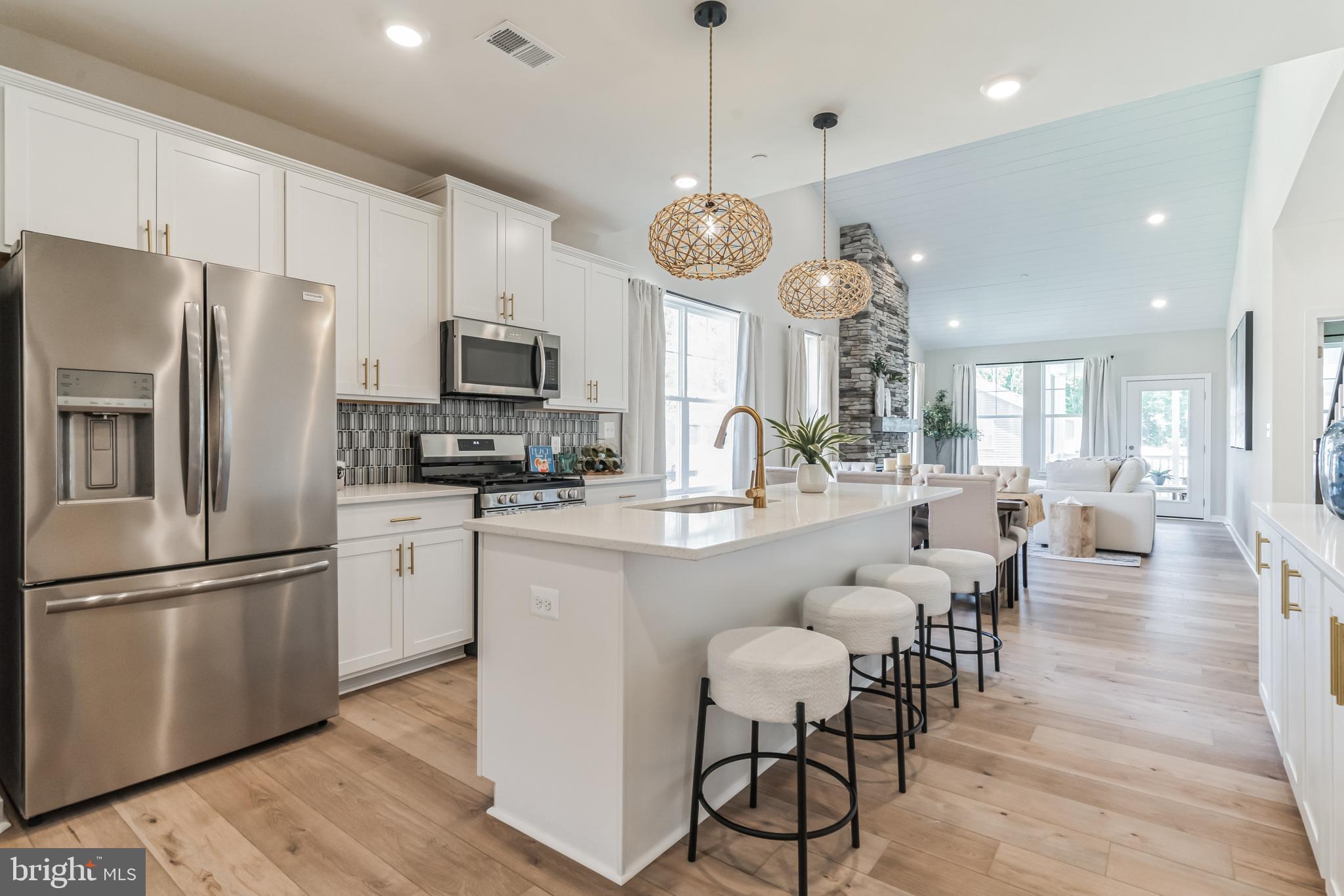 3636 Dexter Court, Unit HARPER142 Aberdeen, MD 21001 - Photo 18 of 40 a large kitchen with stainless steel appliances granite countertop a stove a refrigerator a oven a dining table and chairs with wooden floor