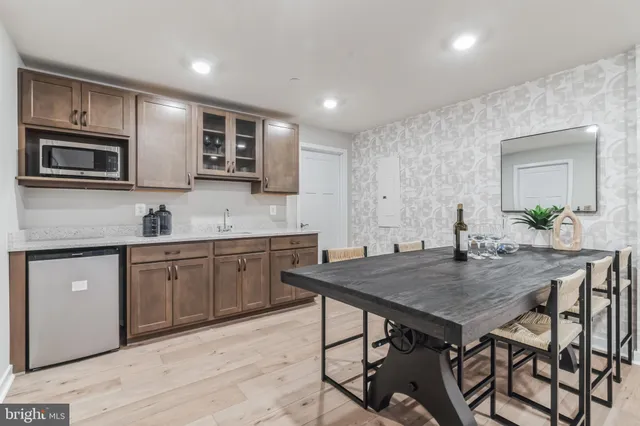 a kitchen with a table chairs microwave and cabinets