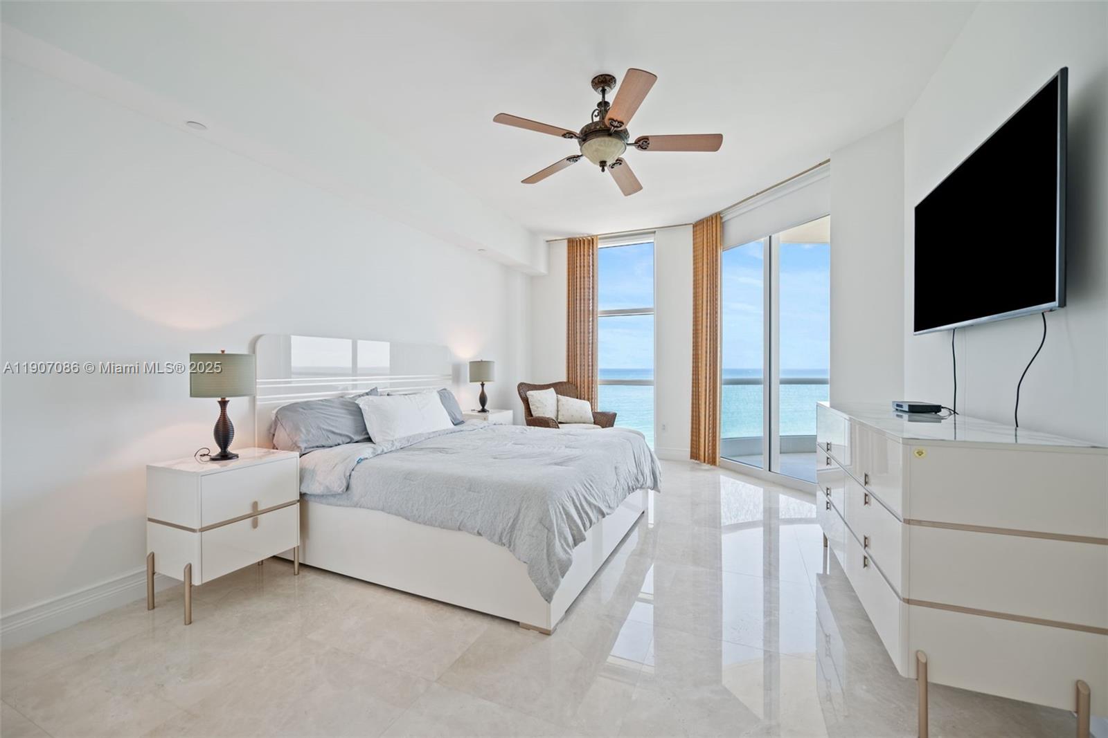16051 Collins Avenue, Unit 1202 Sunny Isles Beach, FL 33160 - Photo 9 of 32 a bedroom with a bed and a flat screen tv