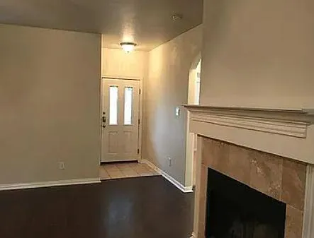 an empty room with wooden floor and fireplace