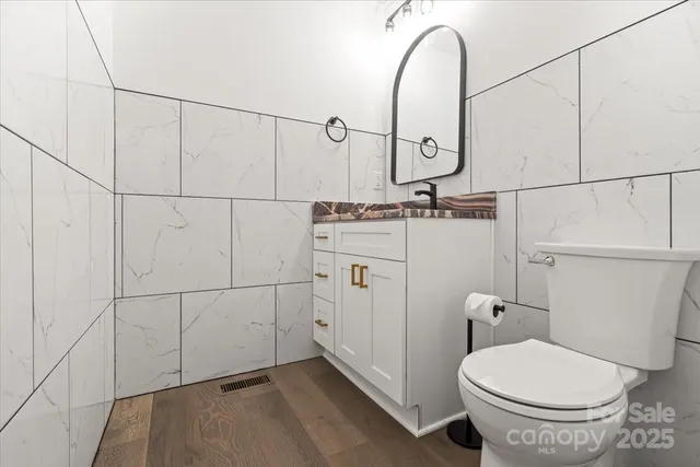 a bathroom with a granite countertop toilet sink and mirror