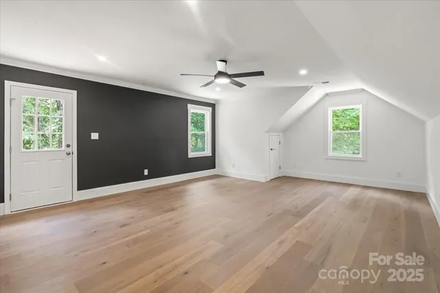 an empty room with windows and a ceiling fan