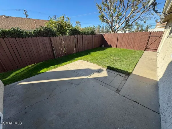 a view of backyard with wooden fence