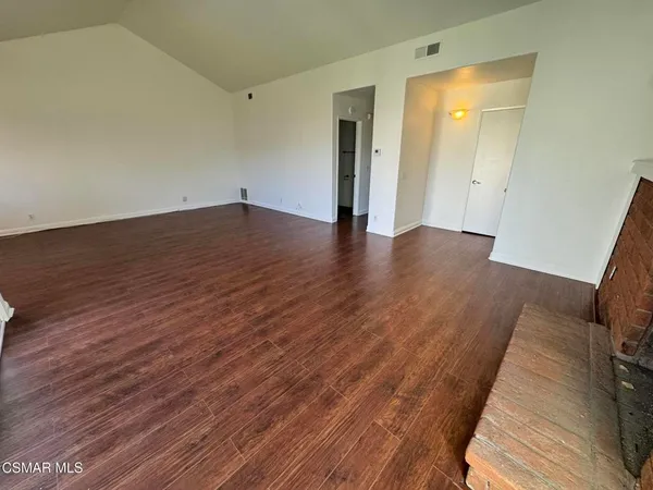 a view of a room with wooden floor and a bathroom