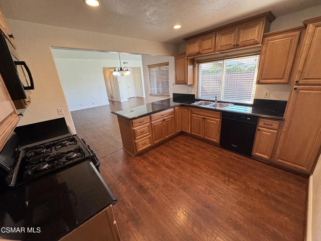 2263 Workman Avenue Simi Valley, CA 93063 - Photo 8 of 17 a kitchen with sink a refrigerator and wooden cabinets