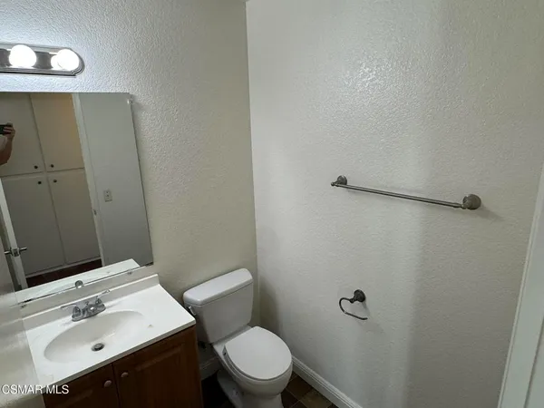 a bathroom with a sink mirror vanity and toilet