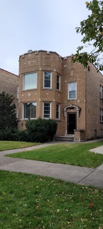 a front view of a house with a garden and yard