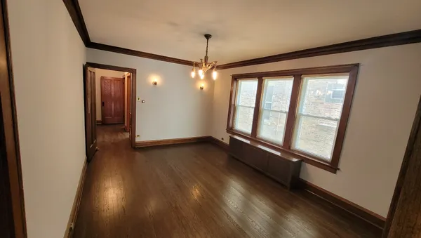 a view of a room with wooden floor and windows